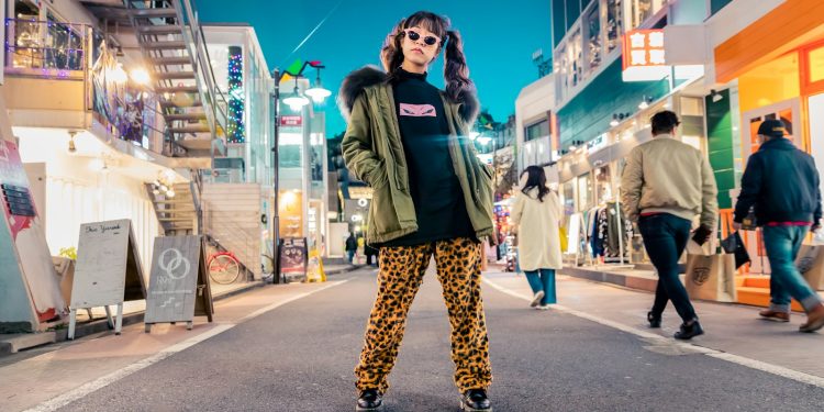 woman in green jacket stands and pose on street